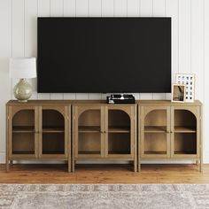 an entertainment center with a flat screen tv mounted on it's sideboard in a living room