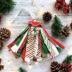 an ornament hanging from a christmas tree with pine cones and candy canes