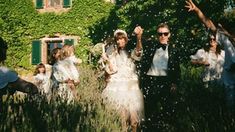 people throwing confetti on each other in front of a building with ivy covered walls