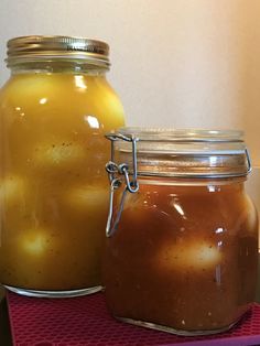 two jars filled with food sitting on top of a red tablecloth covered tray next to each other