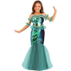 a woman in a green and blue mermaid costume with her arms out, smiling at the camera