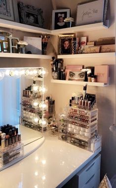 a vanity with lights and makeup on it