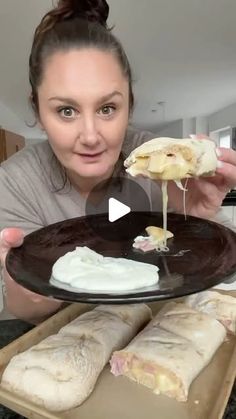 a woman holding a plate with some food on it