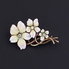 In the language of flowers, white violets were given with the meaning of innocence and purity. This antique brooch (circa 1910-1920) features violets of 14k gold adorned with white enamel and three glittering diamonds. The brooch measures 0.6 inches from top to bottom by 1.3 inches wide. The piece is in good condition with a past enamel repair to the top left petal of the largest flower. We have many other fantastic offerings of fine jewelry posted on our Etsy store, so please consider browsing Elegant Enamel Flower Brooches, Formal Flower-shaped Enamel Brooches, White Enamel Brooch Jewelry, Formal Flower Enamel Brooches, Elegant White Enamel Pin, Elegant Flower Shaped Enamel Pin For Formal Occasions, Elegant Formal Flower Enamel Pin, Elegant Formal Flower Shaped Enamel Pin, Elegant White Enamel Pin For Gift