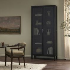 a room with a chair, bookcase and painting on the wall in front of it