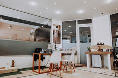 a room with two chairs, a desk and a large mirror on the wall above it