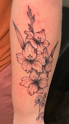 a black and white flower tattoo on the right arm, with flowers in it's center