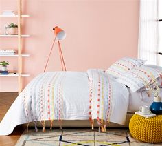 a bedroom with pink walls and white bedding