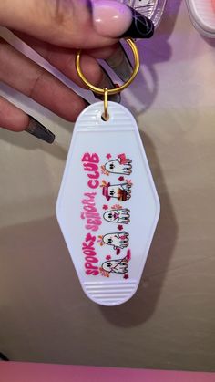 a person holding a keychain with hello kitty on it