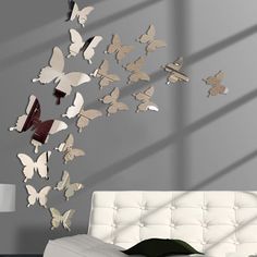 a living room with a white couch and lots of butterflies flying in the air above it