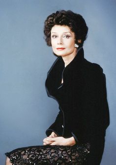 the woman is sitting down wearing a black dress