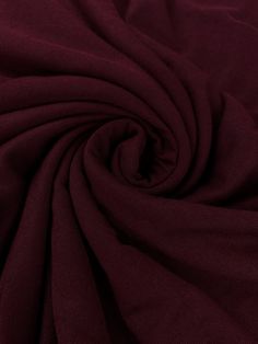 a close up view of the fabric on a plain maroon shirting material that is very soft