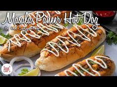 two hot dogs with white sauce on them and garnished with cilantro