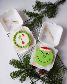 the grin face cake is decorated in green icing and sits next to another cookie