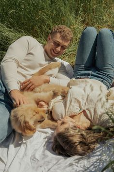 a man and woman laying on the ground with their dogs