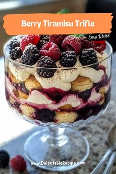 berry triansu trifle in a glass dish with berries and whipped cream on top