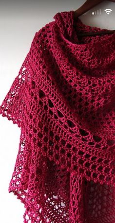 a close up of a knitted shawl on a hanger