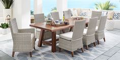 a dining room table and chairs with an ocean view