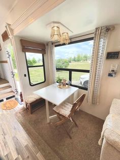 the interior of a mobile home with a dining table and couch in front of a large window