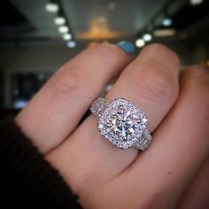 a woman's hand with a diamond ring on top of her finger and an engagement band