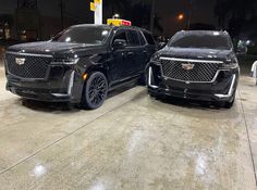 two black suvs parked next to each other