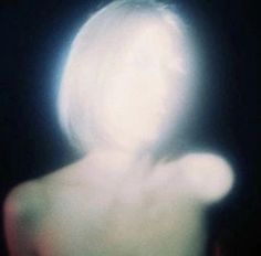 a blurry image of a woman's back in the dark