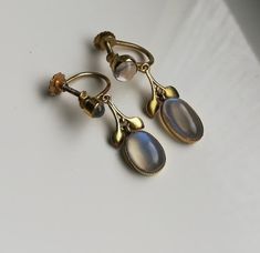 "Please check my own website at www.elegantium.co.uk for my best prices :-) A wonderful extremely rare pair of antique Arts and Crafts earrings by Liberty & Co of London, c1910. They have been crafted in 9ct gold (stamped on the screw back) and show four flashy Ceylon blue moonstones. I adore these stones and the way they flash from clear to the vibrant blue you can see in the images. A similar pair, also with a foliate design,  was sold historically at the fabulous Tadema Gallery in London. I h Antique Clip-on Earrings For Anniversary, Antique Yellow Gold Clip-on Earrings, Antique Wedding Cabochon Earrings, Victorian Gold Jewelry With Moonstone, Victorian Gold Moonstone Jewelry, Victorian Moonstone Gold Jewelry, Vintage Gold Moonstone Jewelry, Vintage Moonstone Jewelry Collectible, Sandra Brown