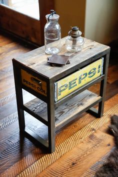 a small wooden table with an old pepsi sign sitting on it's side shelf