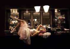 a woman laying on her back in front of a bar