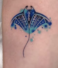 a blue and white tattoo design on the thigh