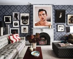 a living room filled with furniture and pictures hanging on the wall above it's fireplace