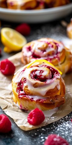 raspberry lemon rolls with icing on parchment paper