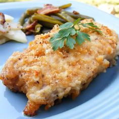 a blue plate topped with chicken, green beans and potatoes