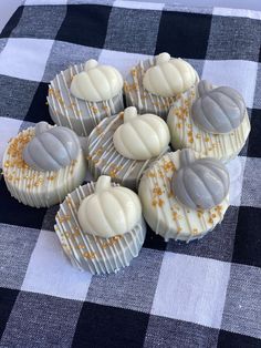 six cupcakes with frosting and sprinkles on a checkered table cloth