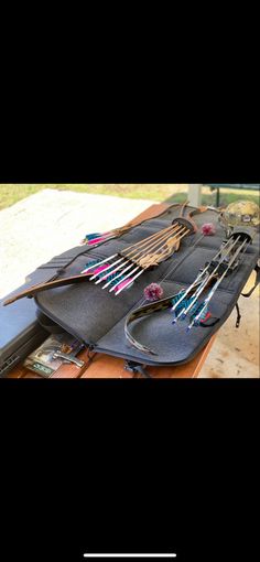 a table topped with lots of different types of bow and arrow bows on top of black plates