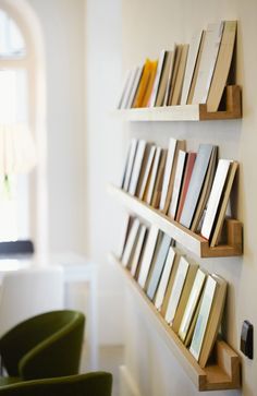 the books are lined up on the wall by the chairs in the dining room area