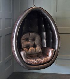 a brown leather chair hanging from the ceiling