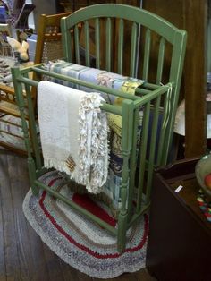 a green baby crib sitting on top of a wooden floor next to other furniture