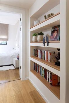 there is a book shelf with books on it in the room next to the bed