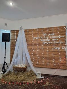 a stage set up for an event with lights on the walls and hay in front of it