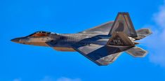 a fighter jet flying through the air on a clear day with blue sky in the background