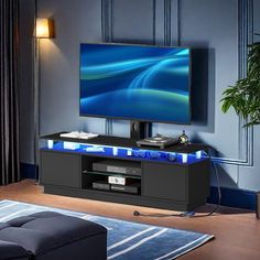 a flat screen tv sitting on top of a black entertainment center in a living room