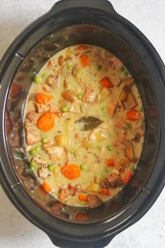 Chicken soup in a black slow cooker bowl that is placed on a white countertop. Juicy Chicken Thighs, Slow Cooker Chicken Stew, Potatoes And Peas, Slow Cooker Chicken Healthy, Carrots Potatoes, Best Soup Recipes, Healthy Slow Cooker