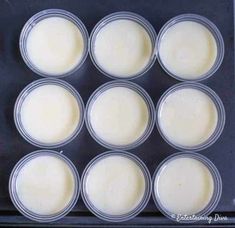 six cups filled with cream sitting on top of a cookie sheet