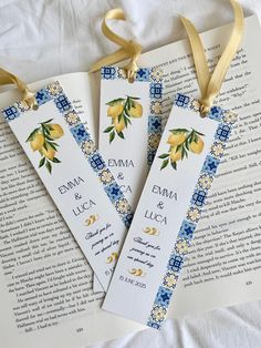 three bookmarks with yellow and blue flowers on them are tied to a gold ribbon