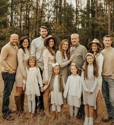 a large family is posing for a photo in the woods with their two children and one adult