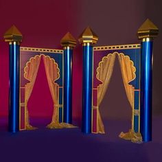 three blue and gold pillars with curtains on them