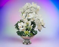 white flowers in a silver vase on a purple and blue background