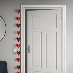 there is a white door with hearts on the wall next to it and a mirror