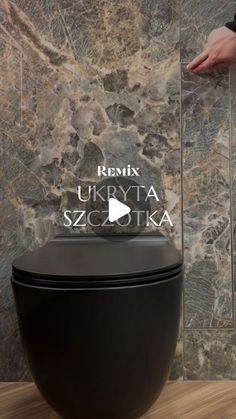 a black toilet sitting on top of a wooden floor